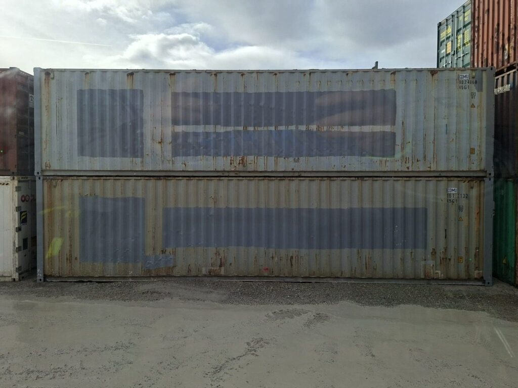 Zwei gebrauchte 40-Fuß-High-Cube-Container gestapelt im Depot
