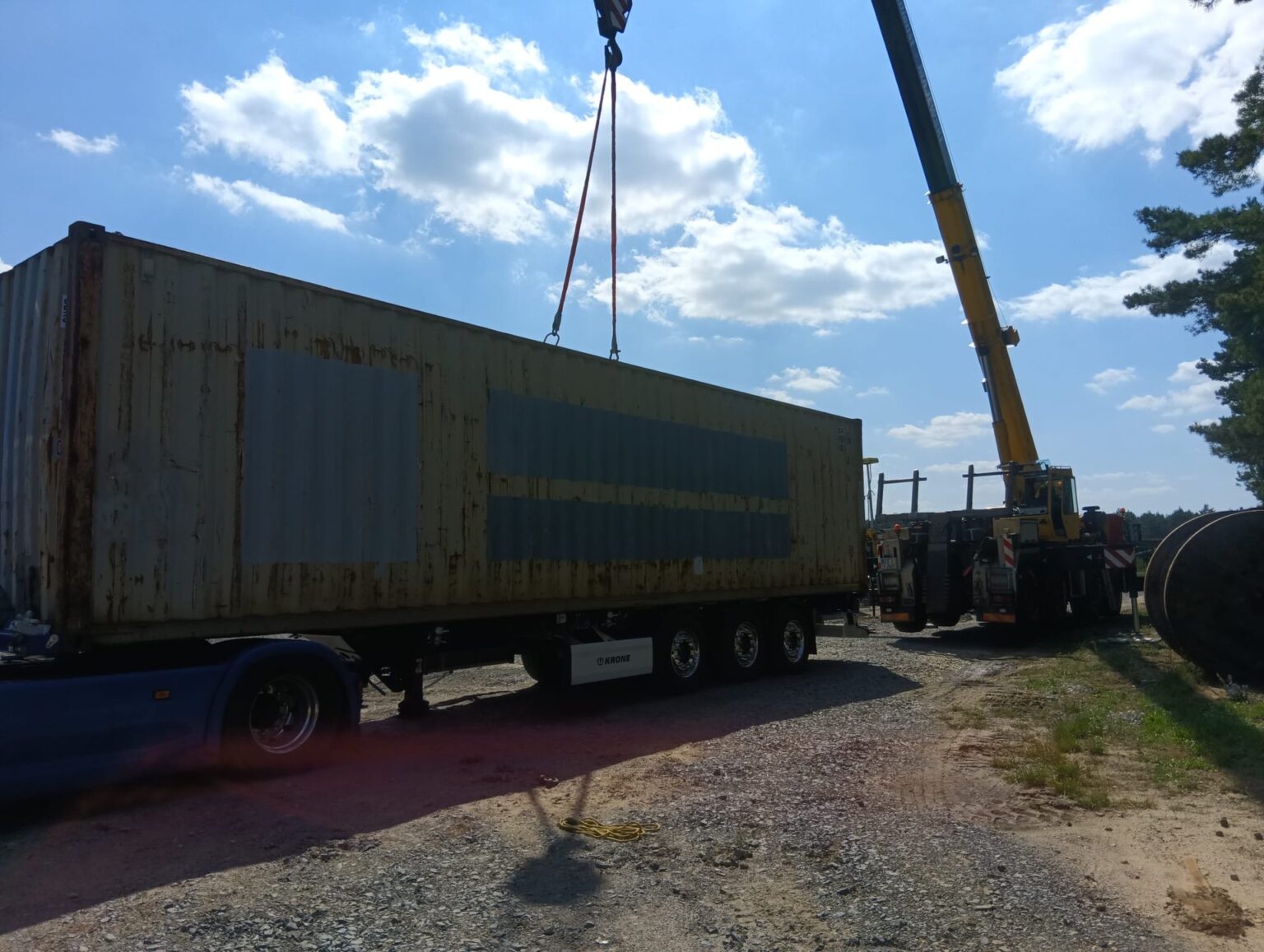 Autokran hebt einen gebrauchten 40-Fuß-Container vom Sattelauflieger
