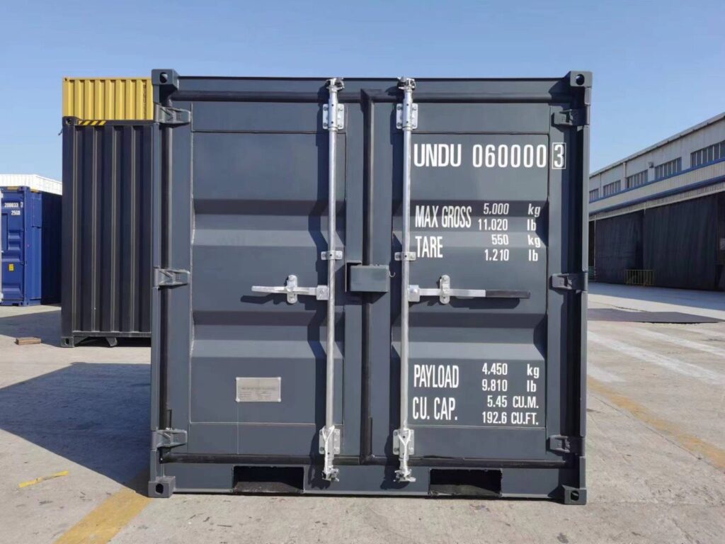 6-Fuß-Container von vorn auf einem Werksgelände, Doppeltür mit Gewichtsangaben